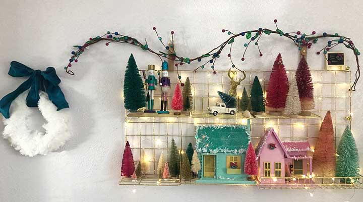 Vintage wooden christmas village surrounded by colorful bottle brush trees.